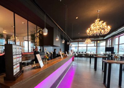 Bild: Moderner Saal mit Kronleuchter, Bar und Lounge-Stehtischen